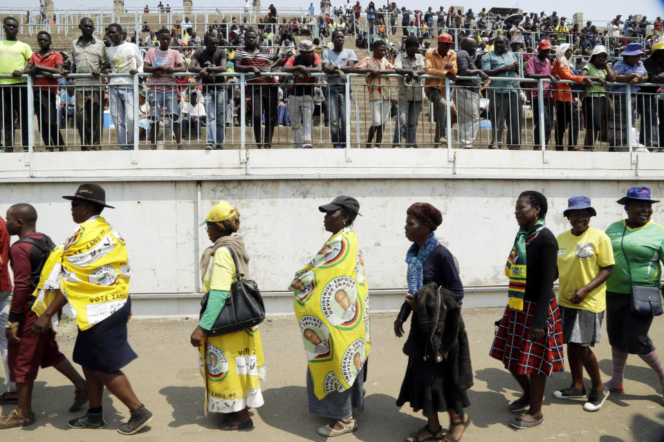 Zimbabweans queue to pay their last respects at the coffin of former Zimbabwean President Robert Mugabe at the Rufaro Stadium in Harare, Friday, Sept. 13, 2019, where the body is on view at the stadium for a second day. Mugabe died last week in Singapore at the age of 95. He led the southern African nation for 37 years before being forced to resign in late 2017. (AP Photo/Themba Hadebe)