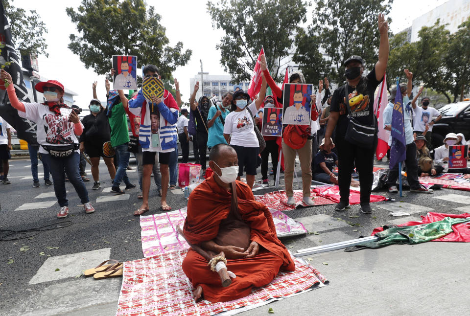 Buddhist monk and pro-democracy activists protest outside the Attorney General office in Bangkok, Thailand, Monday, March 8, 2021. Prosecutors in Thailand charged 18 pro-democracy activists Monday with sedition while lodging additional charges against three of them for defaming the monarchy during protests in September last year. (AP Photo/Sakchai Lalit)