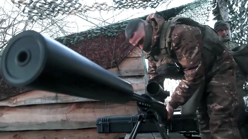 In this photo taken from video and released by the Russian Defense Ministry Press Service on Monday, April 8, 2024, a Russian paratrooper prepares his sniper rifle at the position in an undisclosed location in Ukraine. (Russian Defense Ministry Press Service via AP)