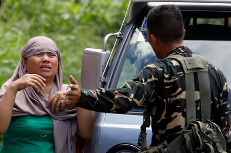 A government soldier stops a woman at a military checkpoint in a residential neighbourhood in Marawi City, due to fighting between government soldiers and the Maute militant group, in southern Philippines May 27, 2017. REUTERS/Erik De Castro