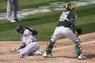 Houston Astros' Yordan Alvarez, left, scores past Oakland Athletics catcher Aramis Garcia during the third inning of a baseball game in Oakland, Calif., Sunday, April 4, 2021. (AP Photo/Jeff Chiu)