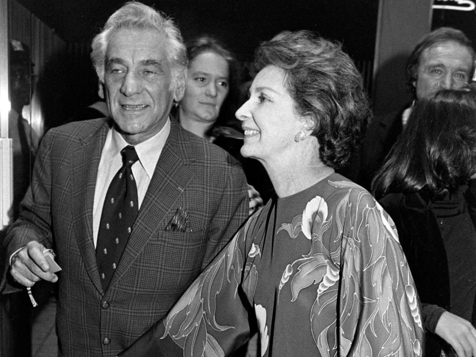 Leonard Bernstein holds Felicia Montealegre's hand as they walk into an event in 1977.