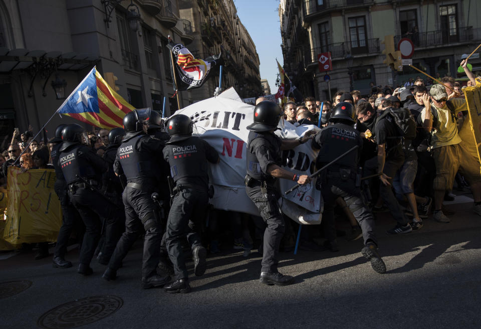 Catalan police officers try to stop pro independence demonstrators, on their way to meet demonstrations by member and supporters of the National Police and Guardia Civil in Barcelona on Saturday, Sept. 29, 2018. (AP Photo/Emilio Morenatti)