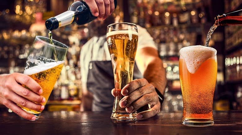 beers being poured into glasses on bar