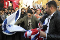 Protesters chant slogans and hold up posters of Gen. Qassem Soleimani while preparing to burn representations of British and Israeli flags, during a demonstration in front of the British Embassy in Tehran, Iran, Sunday, Jan. 12, 2020. A candlelight ceremony late Saturday in Tehran turned into a protest, with hundreds of people chanting against the country's leaders — including Supreme Leader Ayatollah Ali Khamenei — and police dispersing them with tear gas. Police briefly detained the British ambassador to Iran, Rob Macaire, who said he went to the Saturday vigil without knowing it would turn into a protest. (AP Photo/Ebrahim Noroozi)