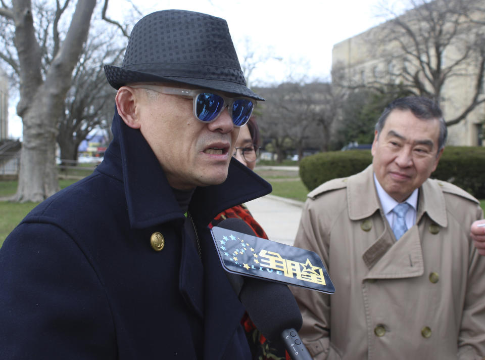 Chinese comedian Zhou Libo, left, arrives with his wife Hu Jie, partially hidden, center, and his attorney Hugh Mo, at the courthouse in Mineola, N.Y., on Long Island where Zhou pleaded not guilty to drug and weapon charges. The comedian and former judge on the "China's Got Talent" television program was arrested during a traffic stop Jan. 19 in Lattingtown, east of New York City. Police said he had been driving erratically and when they stopped him said they noticed a shoulder holster in the back seat and found a loaded pistol and two plastic bags containing crack cocaine in a backpack. (AP Photo/Frank Eltman)