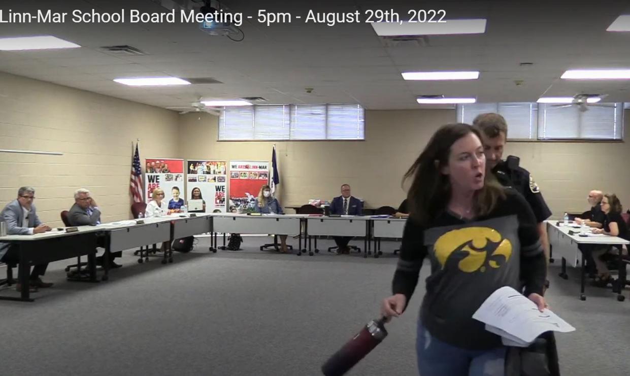 Amanda Snyder is escorted out of a Linn-Mar Community School District board meeting Aug. 29, 2022, after she was accused of being disruptive.