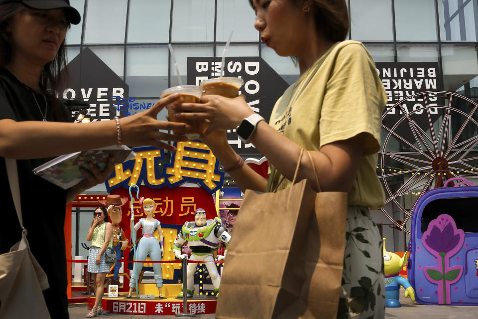 Women stand near the American latest animated film "Toy Story 4" characters on display at the capital city's popular shopping mall in Beijing, Tuesday, June 25, 2019. China says its trade negotiators are talking to their U.S. counterparts on how to resolve disputes ahead of an expected meeting between their two heads of state at the G20 meeting in Japan later this week. (AP Photo/Andy Wong)