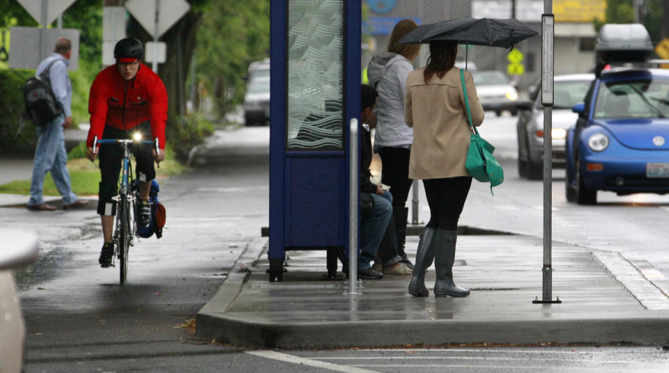 In this May 31, 2012 photo, a bicyclist peddles on a bike lane around a "bus island" and away from a lane of traffic during the morning rush hour in Seattle. For many in Seattle, the image of a typical cyclist is a Spandex-clad, yellow-jacketed two-wheeled warrior who braves the steep streets of this city. But as the city prepares to overhaul its five-year-old bike plan, some are seeking to make the city safer and friendlier to those not so accustomed to navigating the streets on two wheels. There's a new push to get “willing but wary” cyclists on their saddles with protected bike lanes buffered from traffic, designated bicycling boulevards where traffic is slowed and walkers and bikers have priority, and traffic calming features like speed bumps. (AP Photo/Elaine Thompson)