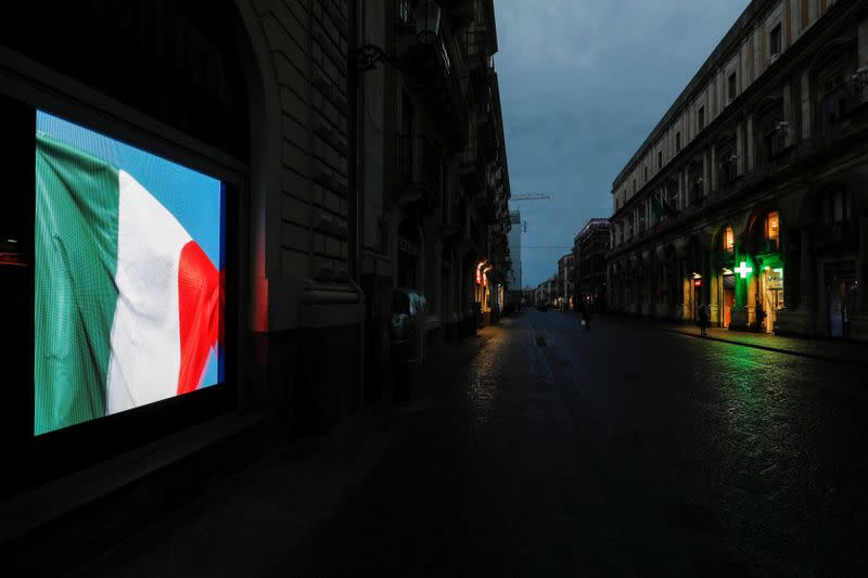 A screen displaying the Italian flag is pictured on an empty street, after Italy reinforced the lockdown measures to combat the coronavirus disease (COVID-19) in Catania, Italy March 21, 2020. REUTERS/Antonio Parrinello