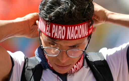 A student puts on a headband reading "National Strike" as he takes part in an anti-government protest in Bogota