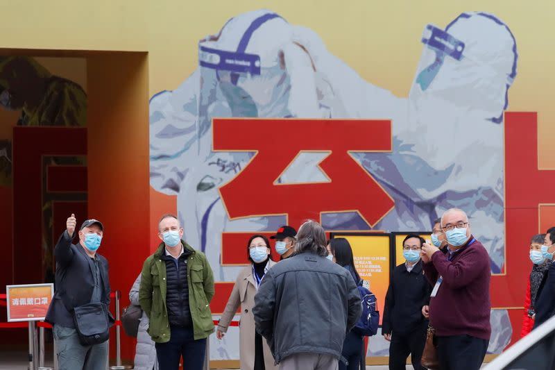 WHO team members visit an exhibition on how China fought the coronavirus in Wuhan