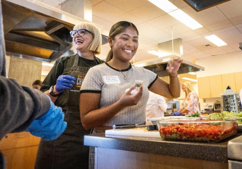 Chef and author Maria Loi of New York laughs with student Rachel Alumna as she puts oregano on a dish they made during an olive oil class for the youth Friday at the UC Davis Olive Center.