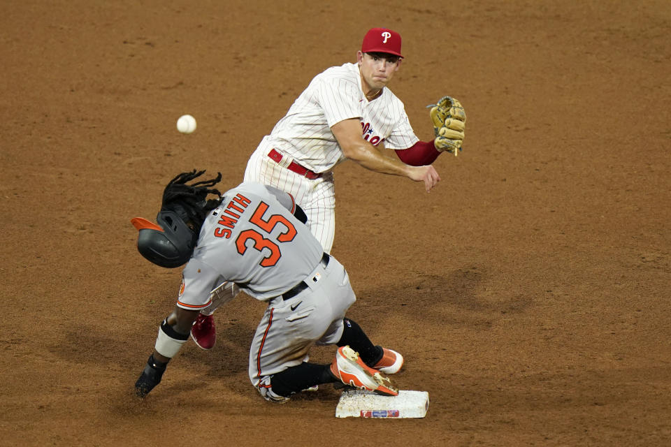 Philadelphia Phillies' second baseman Scott Kingery, top, throws to first after forcing out Baltimore Orioles' Dwight Smith Jr. at second on a fielder's choice by Austin Hays during the sixth inning of a baseball game, Tuesday, Aug. 11, 2020, in Philadelphia. Hays was safe at first on the play. (AP Photo/Matt Slocum)