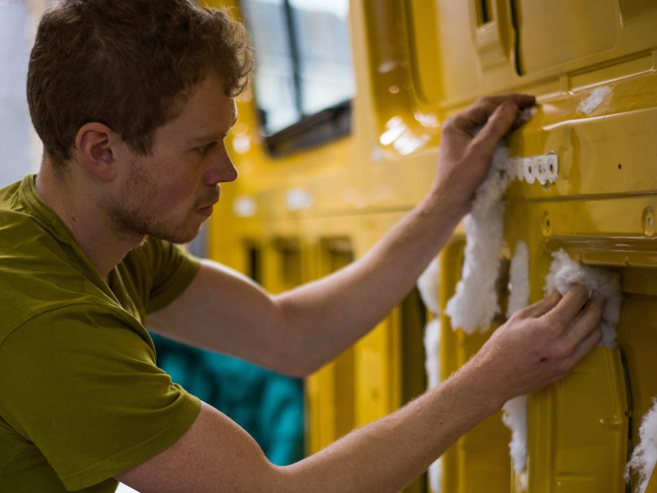 Dale Comley adding insulation to the walls of the van.