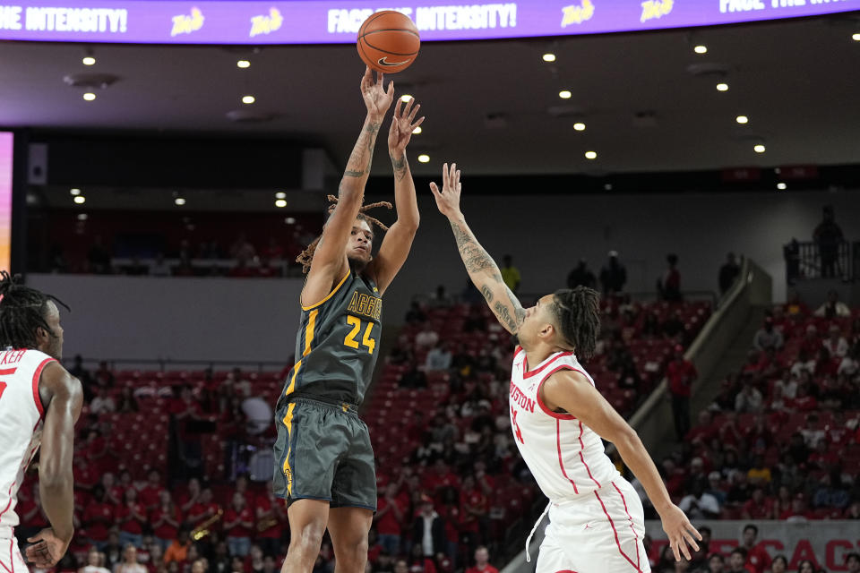 North Carolina A&T guard Demetric Horton (24) takes a shot over Houston guard Ramon Walker Jr. (3) during the first half of an NCAA college basketball game, Tuesday, Dec. 13, 2022, in Houston. (AP Photo/Kevin M. Cox)