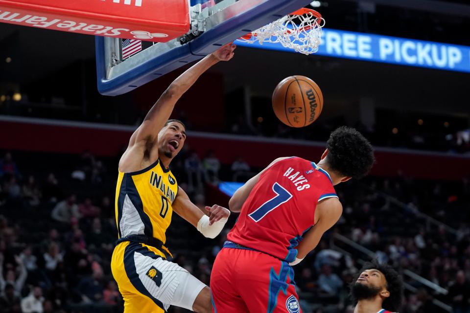 Indiana Pacers guard Tyrese Haliburton (0) dunks on Detroit Pistons guard Killian Hayes (7) in the second half of an NBA basketball game in Detroit, Friday, March 4, 2022.