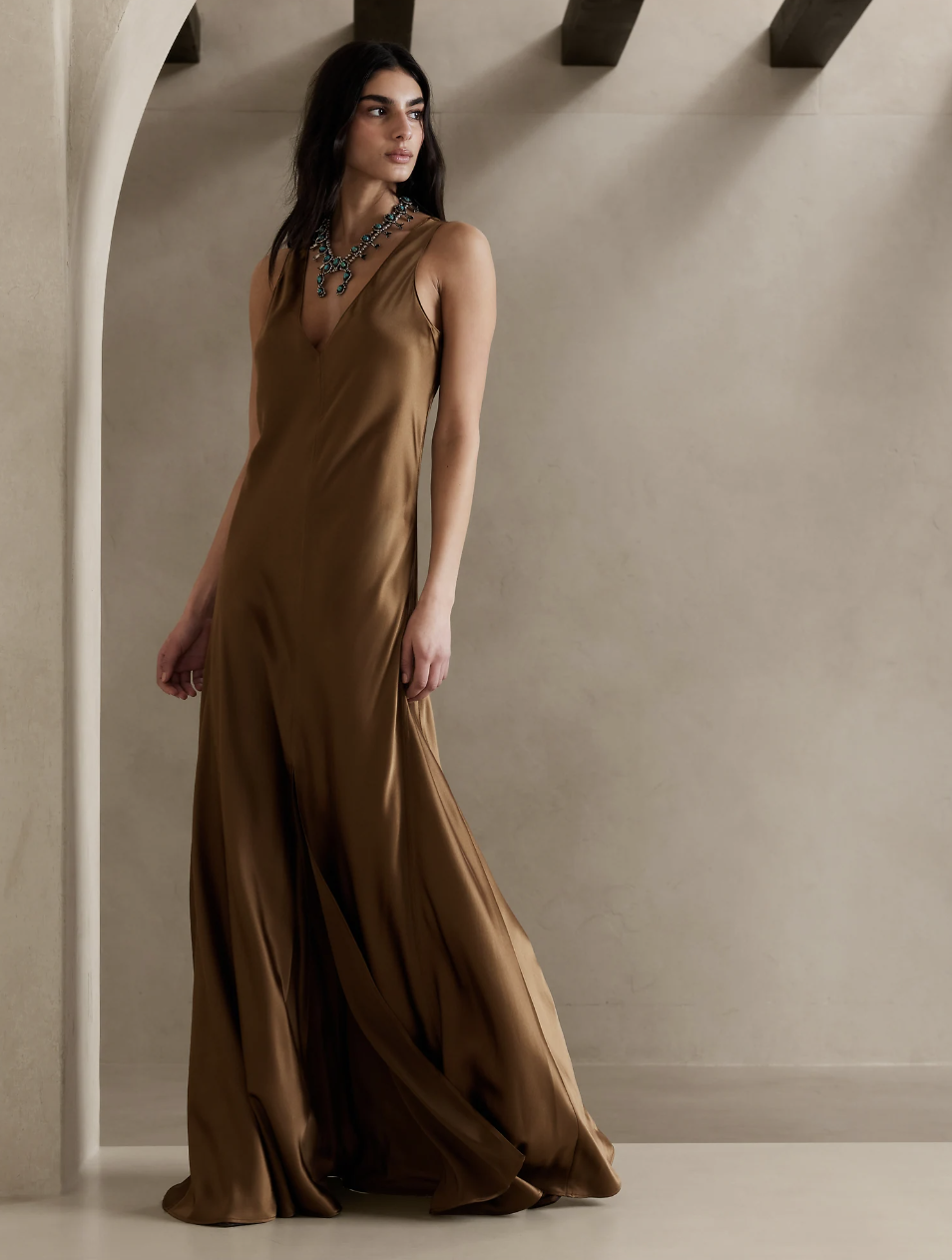 brunette model wearing gold brown silk dress, Eterno Silk Maxi Dress (Photo via Banana Republic)