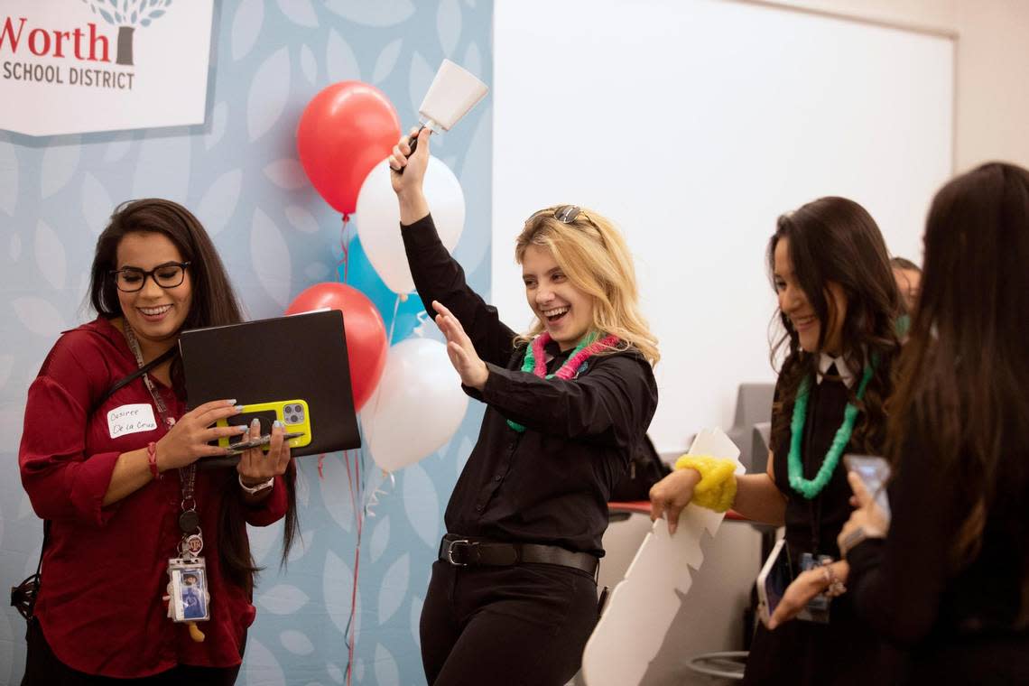 Recruitment coordinator Christina Morrow rings a cow bell, signifying a teacher candidate has been matched with a school during the Fort Worth Independent School District Summer Mega Career Fair on June 7, 2022, at the FWISD Teaching & Learning Center.