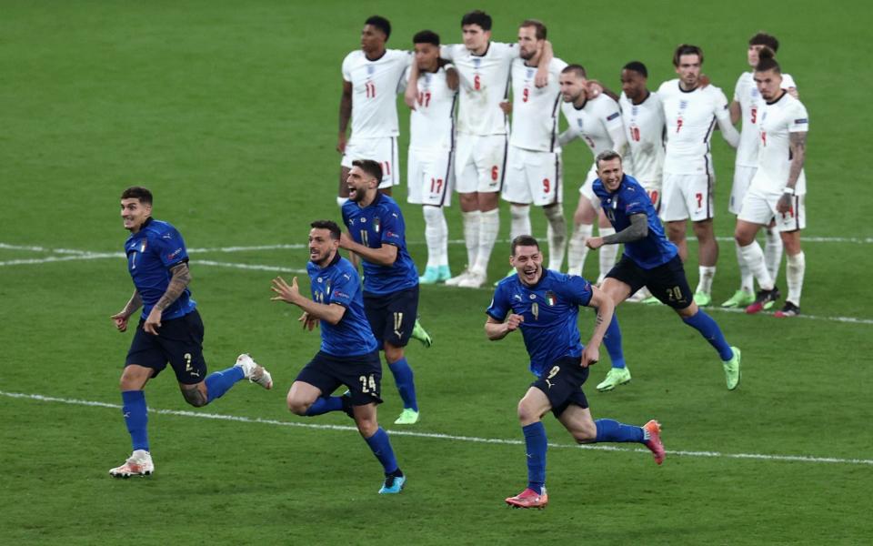 Players of Italy celebrate following victory in the penalty shoot out as players of England look dejected during the UEFA Euro 2020 final - Getty Images