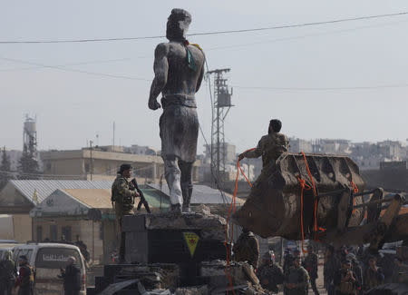 Turkish-backed Free Syrian Army members pull down Kurdish statue in center of Afrin, Syria March 18, 2018. REUTERS/Khalil Ashawi