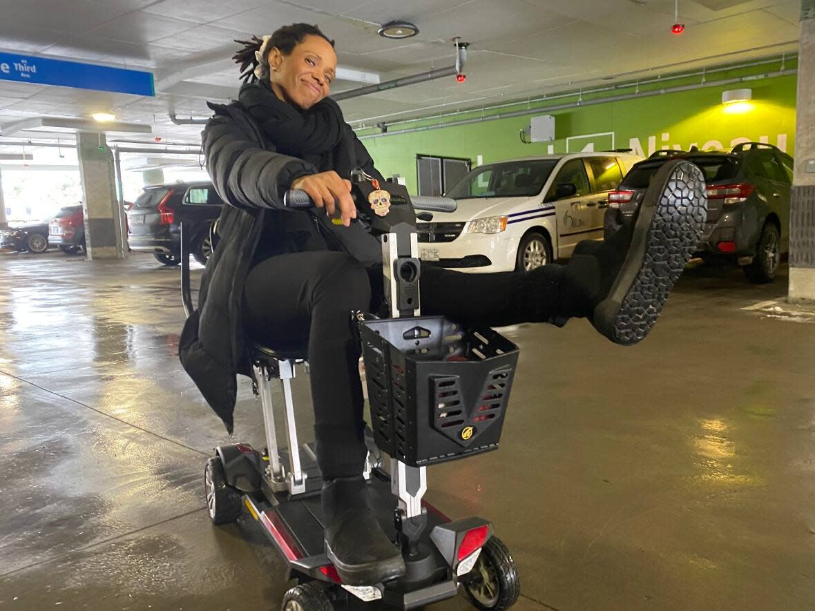 Ottawa jazz singer Kellylee Evans poses for a photo with her mobility scooter, lovingly nicknamed 'Sunny.' (Alan Neal/CBC - image credit)