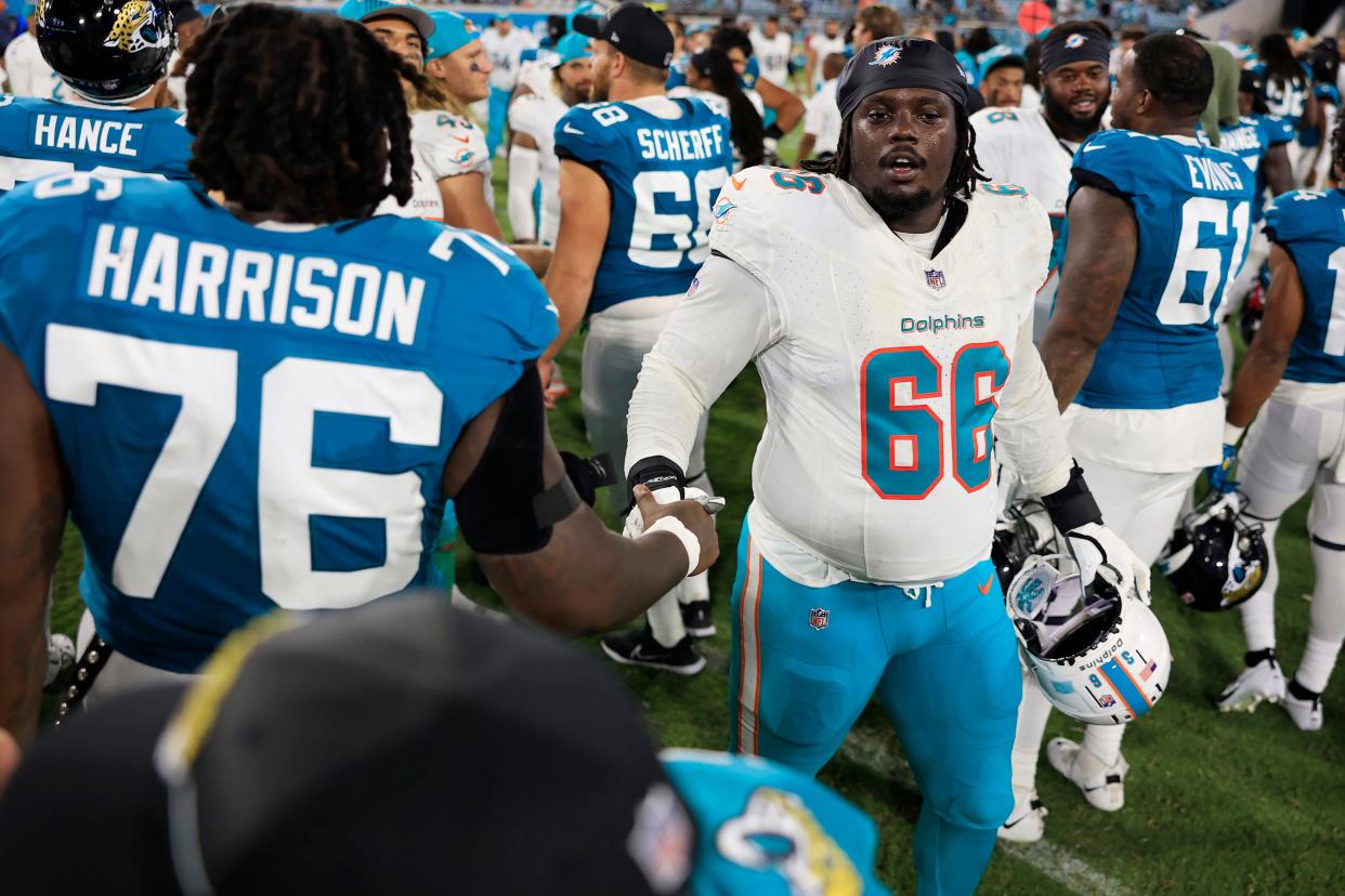 Miami Dolphins guard Lester Cotton (66) greets Jacksonville Jaguars offensive tackle Anton Harrison (76) after the game of a preseason matchup Saturday, Aug. 26, 2023 at EverBank Stadium in Jacksonville, Fla. The game was suspended in the fourth after Miami Dolphins wide receiver Daewood Davis (87) was injured on a play with a final score of 31-18.