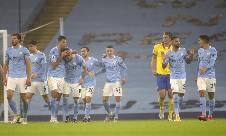 Los jugadores del Manchester City festejan el gol de Phil Foden (centro) en la victoria 1-0 ante Brighton en la Liga Premier inglesa, el miércoles 13 de enero de 2021, en Manchester. (Martin Rickett /Pool vía AP)