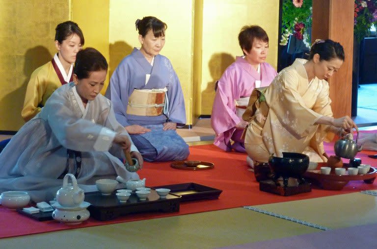 A Chinese (L) and Japanese style (R) tea ceremony is held at the tea museum in Shimada city, Shizuoka prefecture, on May 2, 2013. The World Tea Festival this month celebrated the liquid in all its forms, from the earthenware teapots used in Japan to the delicate bone china of an English cup and saucer; from Russian samovars to the short, sweet, shot-sized glasses drunk in Turkey