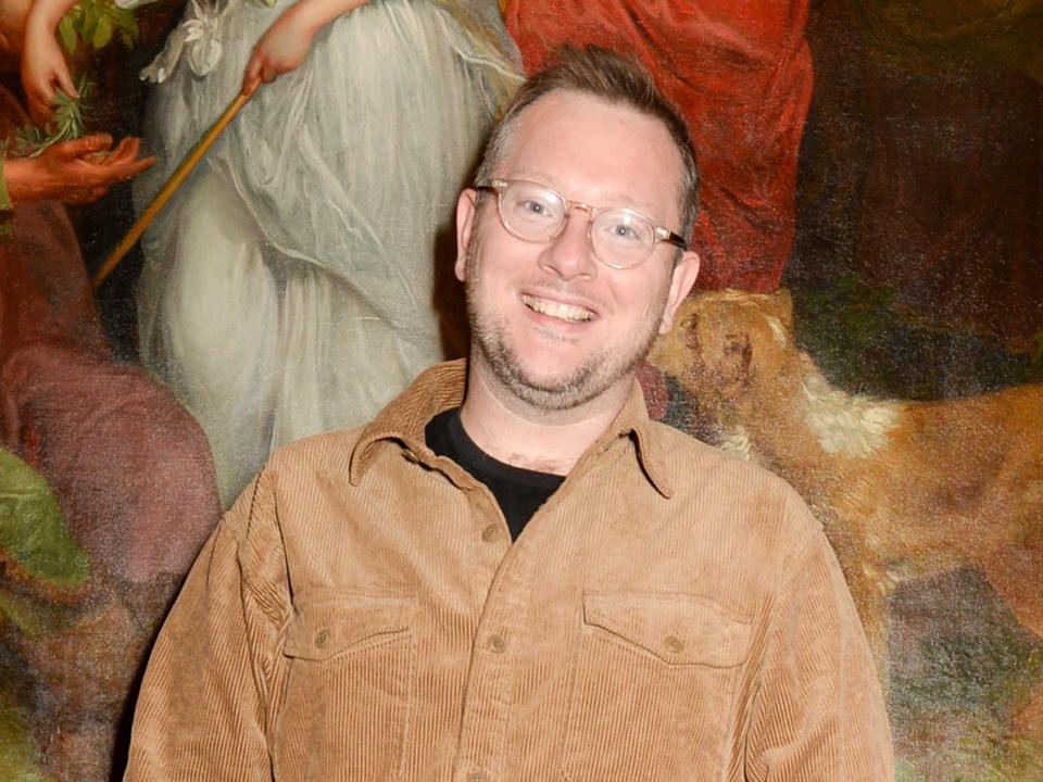 Edd smiling in glasses with some facial hair in corduroy shirt.