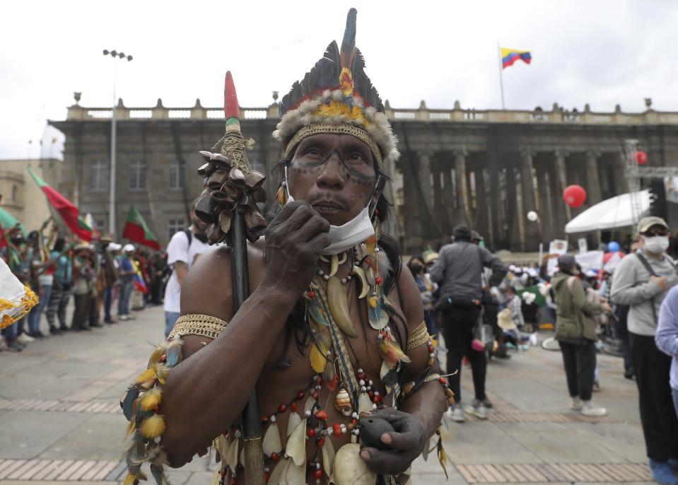 An Indigenous man arrives to Plaza Bolivar to take part in a demonstration against the government’s handling of a wide range of issues including the economic fallout of the pandemic and implementation of the peace accord, in Bogota, Colombia, Wednesday, Oct. 21, 2020. Indigenous leaders, students and union members gathered at in the historic square waving flags and banners decrying the government nearly one year after massive protests rocked the country only to fizzle with little to show by way of reform. (AP Photo/Fernando Vergara)