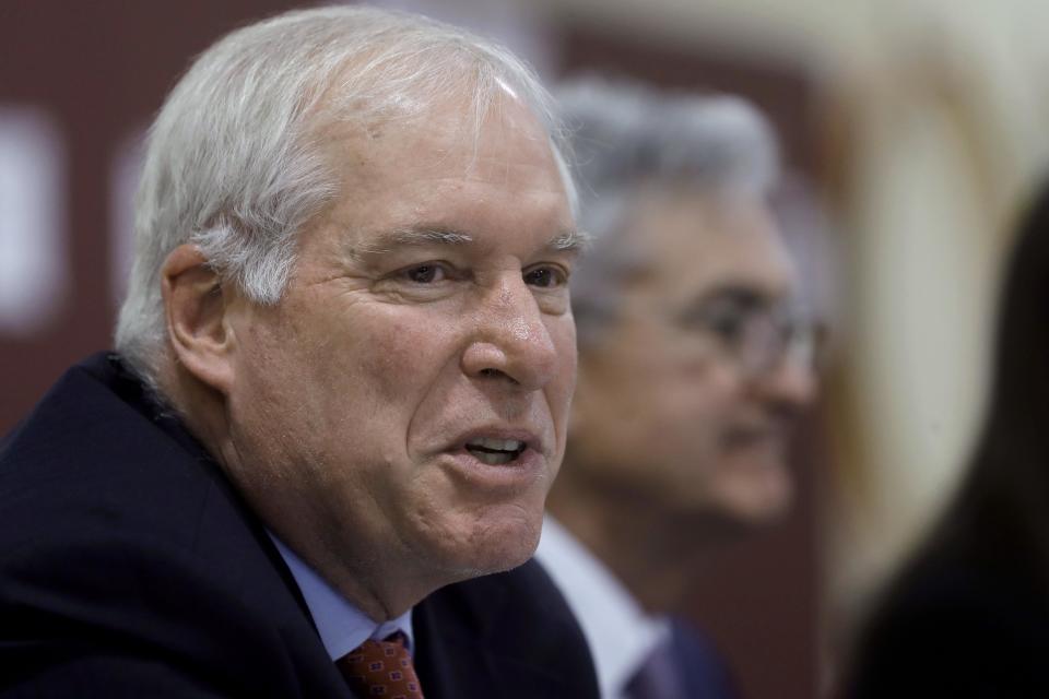 FILE - In this Nov. 25, 2019 file photo Federal Reserve Bank of Boston President Eric Rosengren, left, speaks during a round table discussion at Silver Lane Elementary School, in East Hartford, Conn. Rosengren  on Friday, Aug. 7, 2020 defended the central bank’s efforts to launch a Main Street lending program and said the small number of loans approved so far would likely expand by a significant amount in coming months, especially if the pandemic worsens.  (AP Photo/Steven Senne, file)