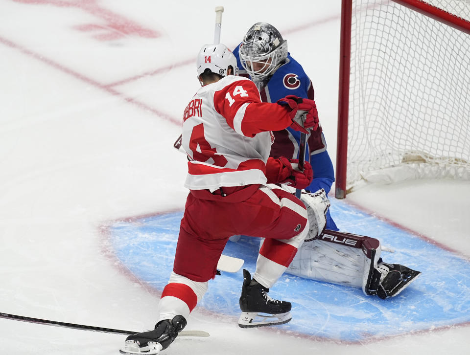 Detroit Red Wings center Robby Fabbri, front, scores a power-play goal against Colorado Avalanche goaltender Alexandar Georgiev in the first period of an NHL hockey game Wednesday, March 6, 2024, in Denver. (AP Photo/David Zalubowski)