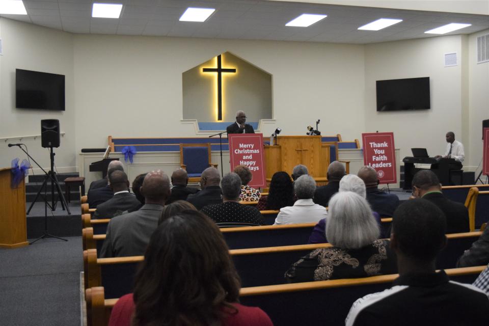 Mt. Pleasant Baptist Church Rev. Gerald Toussaint talks with church congregants and faith leaders on Dec. 8, 2022, after the building was destroyed by fire in 2019 and rebuilt.