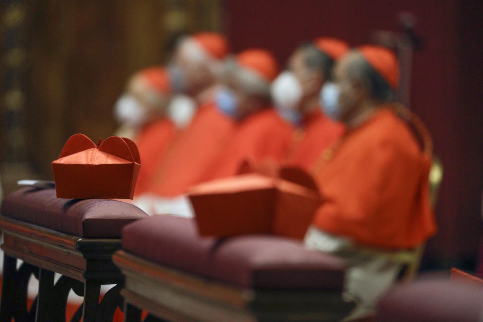 FILE - Cardinals sit as Pope Francis celebrates Mass the day after he raised 13 new cardinals to the highest rank in the Catholic hierarchy, at St. Peter's Basilica, Sunday, Nov. 29, 2020. Pope Francis has ordered pay cuts for Holy See employees, including slashing cardinals’ salaries by 10%. Francis in a letter made public by the Vatican on Wednesday, March 24, 2021, noted that the pandemic emergency “negatively impacted all sources of revenue” for the Holy See and Vatican City State. (AP Photo/Gregorio Borgia, File)