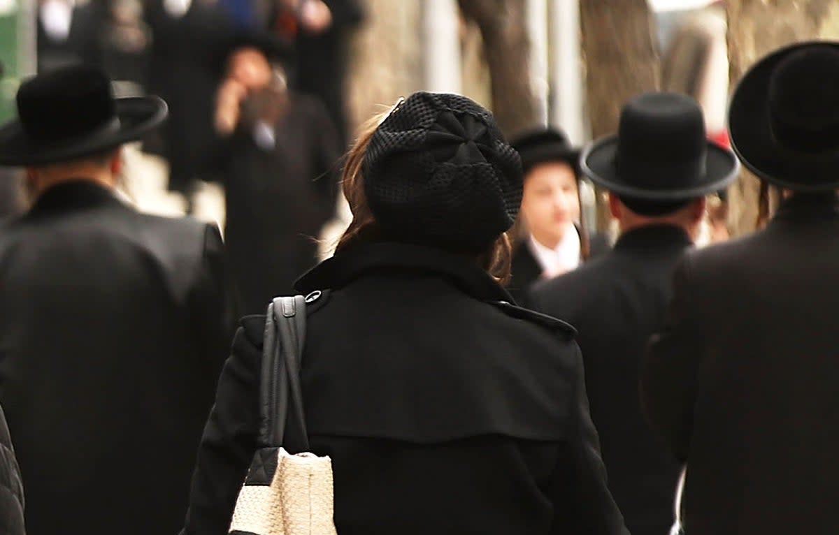 Hasidic men and women walk through a Jewish Orthodox neighborhood in Brooklyn on April 24, 2017 in New York City. (Spencer Platt/Getty Images)