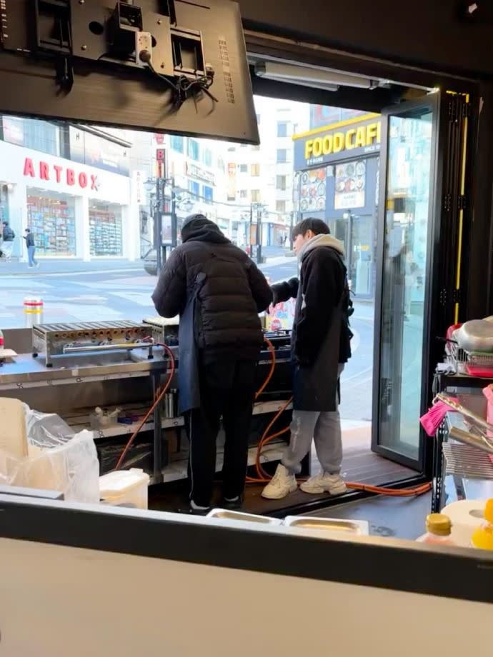 中國網友偶遇到國憲和有彬在濟州島開了章魚燒店，原本還在感嘆，結果粉絲表示只是在拍vlog。（圖／翻攝自微博）