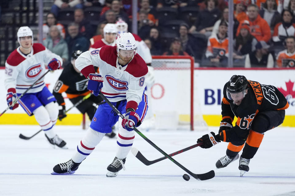 Montreal Canadiens' Mike Matheson (8) battle for the puck against Philadelphia Flyers' Olle Lycksell (62) during the third period of an NHL hockey game, Friday, Feb. 24, 2023, in Philadelphia. (AP Photo/Matt Slocum)