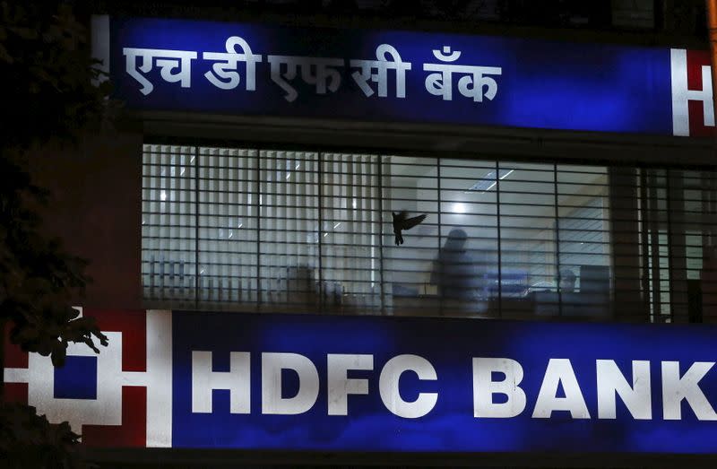 A bird flies past a window of a HDFC Bank branch office in Mumbai