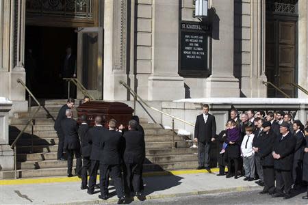 Mimi O'Donell, former partner of actor Phillip Seymour Hoffman, holds their daughter Willa (in purple) next to their son Cooper as the casket arrives for Hoffman's funeral in the Manhattan borough of New York, February 7, 2014. REUTERS/Brendan McDermid