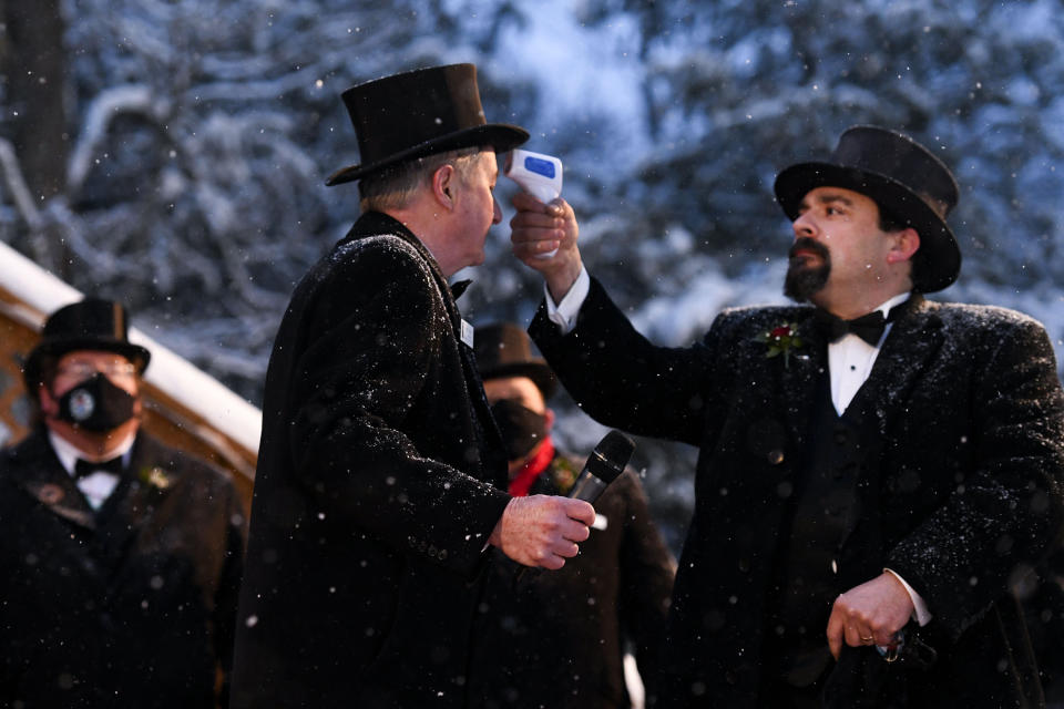 Groundhog Club Inner Circle member Dave Gigliotti checks the temperature of President Jeff Lundy during the 135th celebration of Groundhog Day on Gobbler's Knob in Punxsutawney, Pa., Tuesday, Feb. 2, 2021. Phil's handlers said that the groundhog has forecast six more weeks of winter weather during this year's event that was held without anyone in attendance due to potential COVID-19 risks. (AP Photo/Barry Reeger)