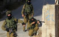 Israeli soldiers hold a position in a street, east of the West Bank city of Nablus, on October 3, 2015, as they search for the suspected Palestinian killers of a Jewish settler couple