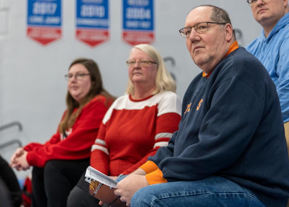 Peter Groote, with wife Pam Groote and daughter Sarah Groote (far left), watches the North Central High School boys play at Roncalli High School, Tuesday, Jan 11, 2023, as they tick off another in their quest to see a basketball game in every high school gym in the state. The couple is hoping to finish their quest in the next seven years, before retirement. 