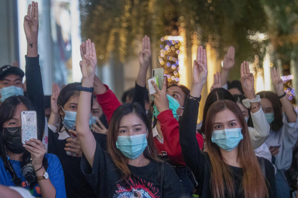 Pro-democracy activists flash three-fingered salutes during a rally outside Siam Paragon, one of the largest shopping malls, in Bangkok, Thailand, Tuesday, Oct. 20, 2020. Thailand's Cabinet on Tuesday approved a request to recall Parliament for a special session to deal with the political pressures from ongoing anti-government protests. The Cabinet at its weekly meeting approved the request, which calls for a non-voting session on Oct. 26-27. (AP Photo/Sakchai Lalit)