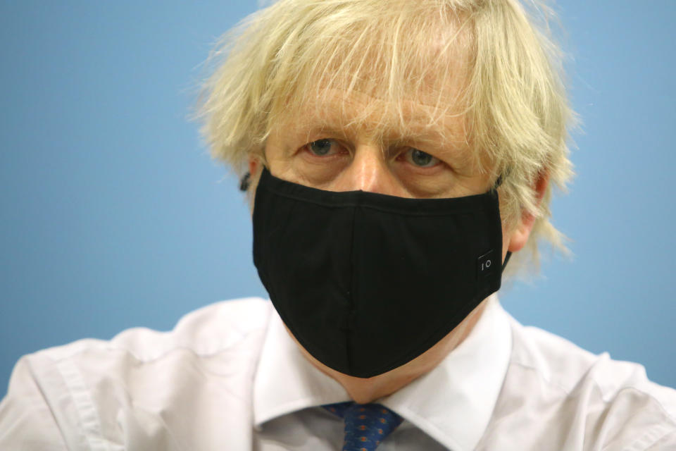 CWMBRAN, WALES – FEBRUARY 17: British Prime Minister Boris Johnson wears a face mask with the number 10 on it during a visit to the vaccination centre at Cwmbran Stadium on February 17, 2021 in Cwmbran, Wales. The Prime Minister visited the vaccination centre to see the progress of the COVID-19 vaccine roll out in Wales. During the visit he explained that the lifting of the coronavirus lockdown would be “based firmly on a cautious and prudent approach”. (Photo by Geoff Caddick – WPA Pool/Getty Images)