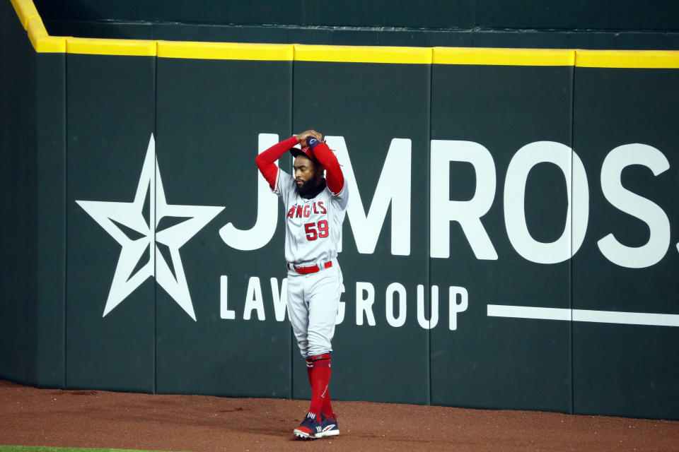 Los Angeles Angels right fielder Jo Adell puts his hands on his head after a fly ball by Texas Rangers' Nick Solak popped out of his glove and over the right field wall for a solo home run during the fifth inning of a baseball game in Arlington, Texas, Sunday, Aug. 9, 2020. (AP Photo/Ray Carlin)