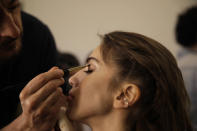 A model is made up backstage ahead of the John Richmond men's Spring-Summer 2020 collection, unveiled during the fashion week, in Milan, Italy, Sunday, June 16, 2019. (AP Photo/Luca Bruno)