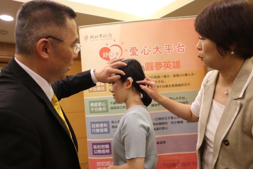 科林助聽器協理陳俊旭（左）向新北市副秘書長龔雅雯（右）說明造型係根據兒童的耳蝸利用3D列印設計製作，非常的精巧。（新北市社會局提供）