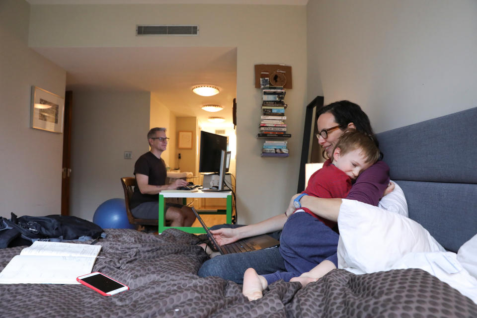 Naomi Hassebroek holds her son Felix while working with her husband Doug Hassebroek at their home, after New York State Governor Andrew Cuomo signed an executive order closing New York public schools statewide due to public health concerns over the rapid spread of coronavirus disease (COVID-19) in Brooklyn, New York, U.S., March 19, 2020. REUTERS/Caitlin Ochs