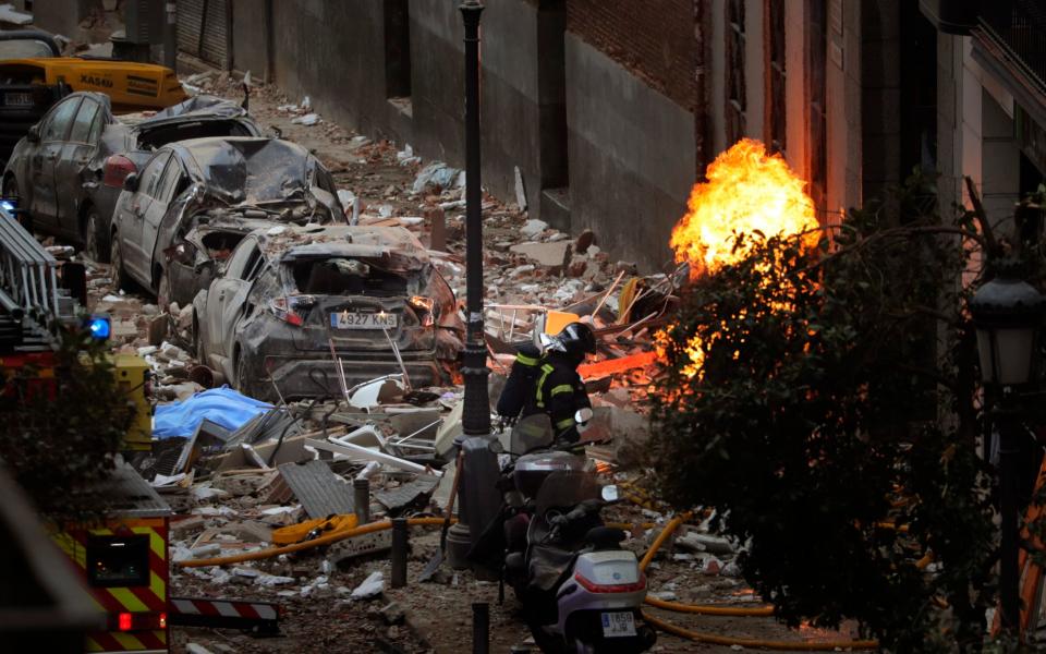 Wreckage lines the Madrid street as firefighters deal with explosion's aftermath - AP